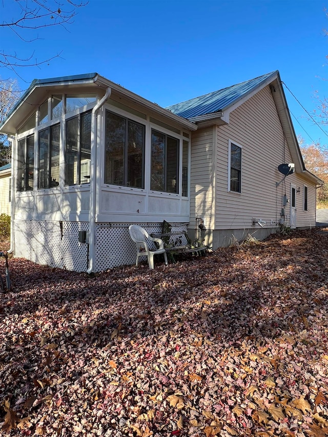 view of property exterior featuring a sunroom