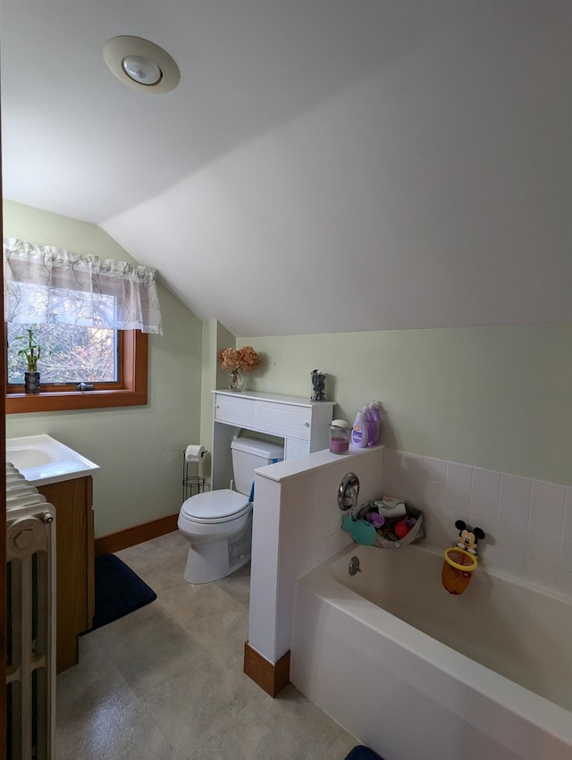 bathroom featuring a bathtub, toilet, lofted ceiling, and vanity