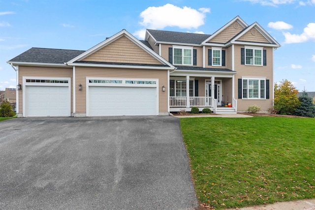 view of front of house with a garage, covered porch, driveway, and a front yard