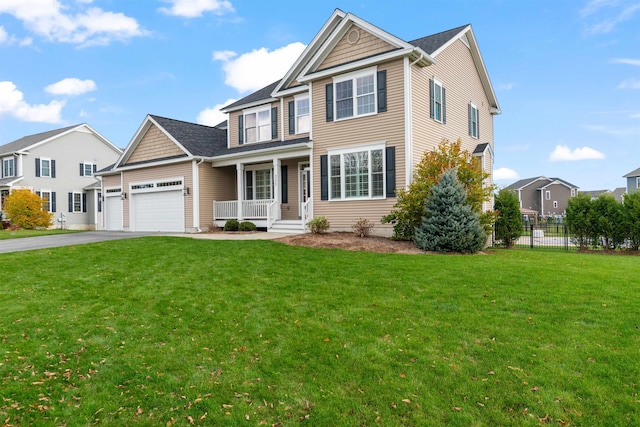 traditional-style home featuring a garage, a front lawn, driveway, and fence