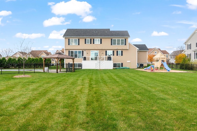 rear view of property with fence, a yard, a gazebo, a playground, and a residential view