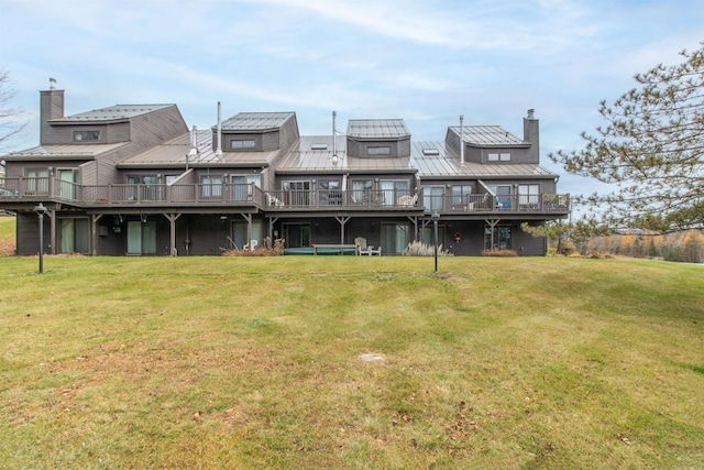 back of house with a deck and a lawn