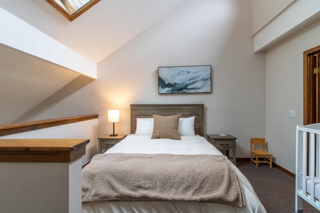 carpeted bedroom featuring lofted ceiling with skylight