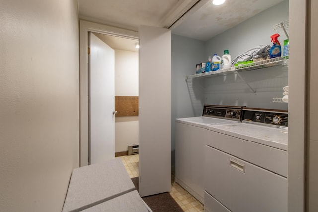 clothes washing area featuring washer and dryer and a baseboard radiator