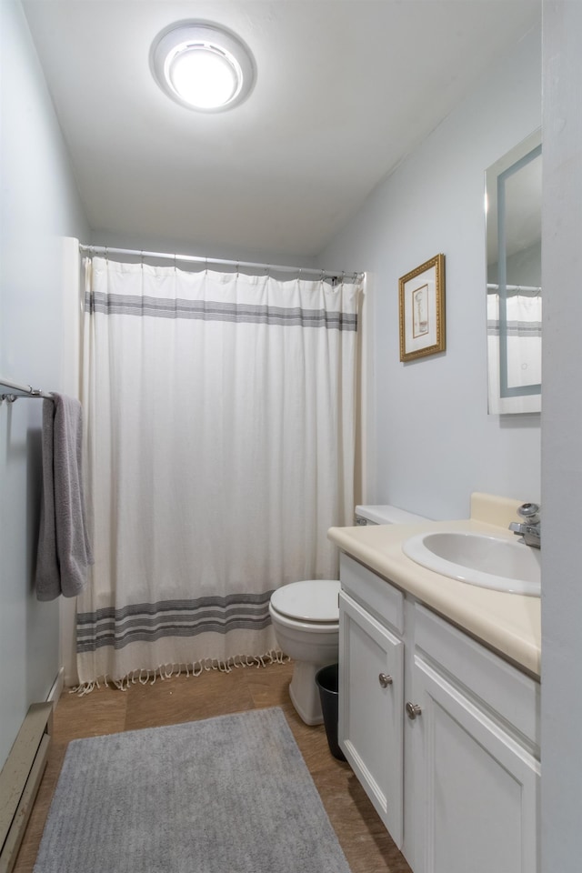 bathroom featuring curtained shower, hardwood / wood-style floors, toilet, baseboard heating, and vanity