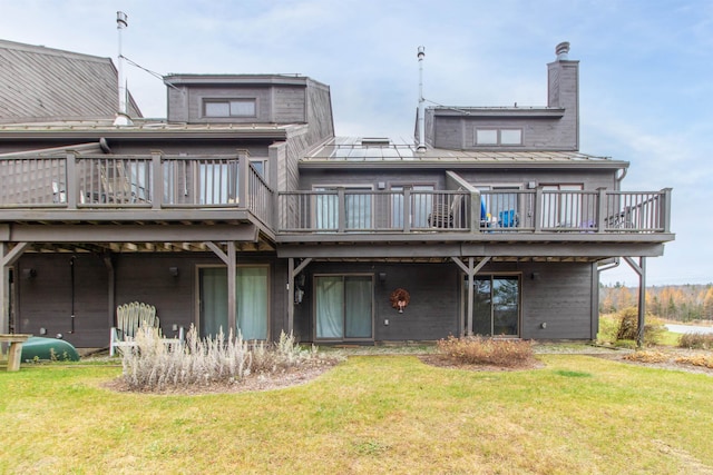 back of house featuring a deck and a lawn