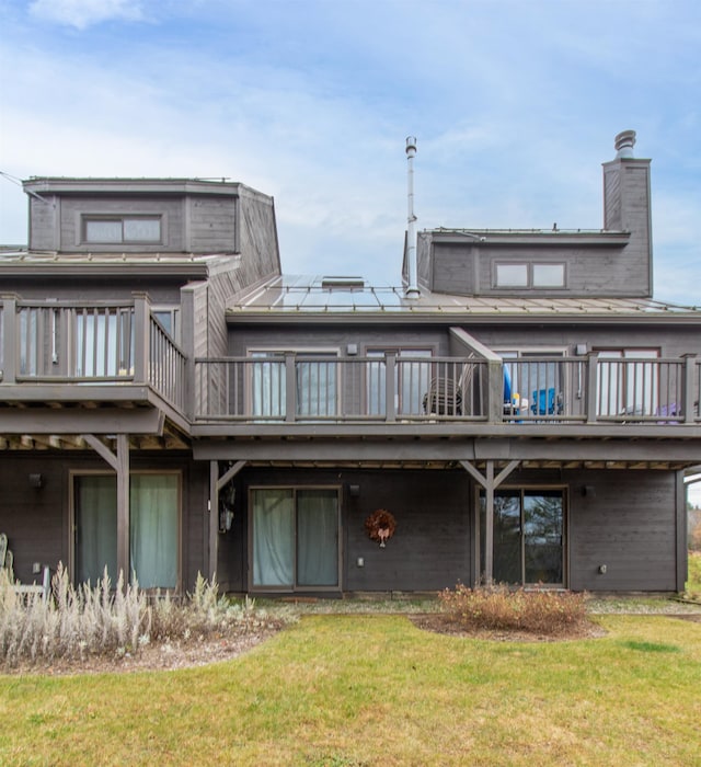 rear view of property with a yard and a deck