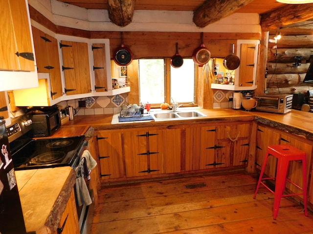 kitchen featuring electric stove, sink, beamed ceiling, light hardwood / wood-style flooring, and log walls