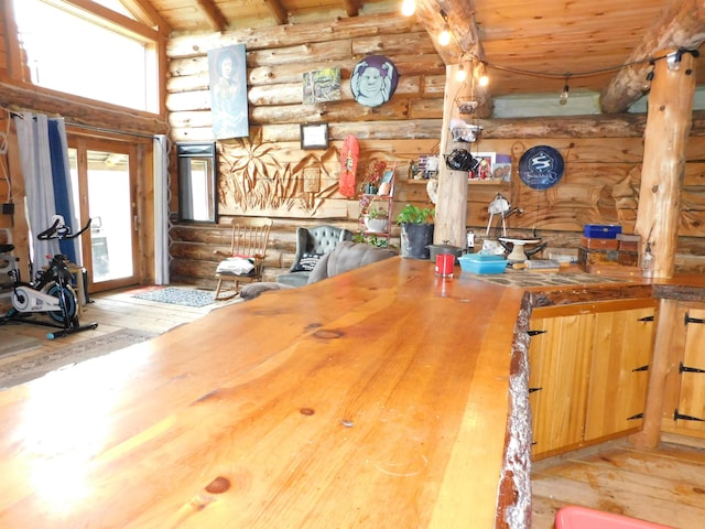 kitchen featuring vaulted ceiling with beams, wood ceiling, wood counters, light wood-type flooring, and log walls