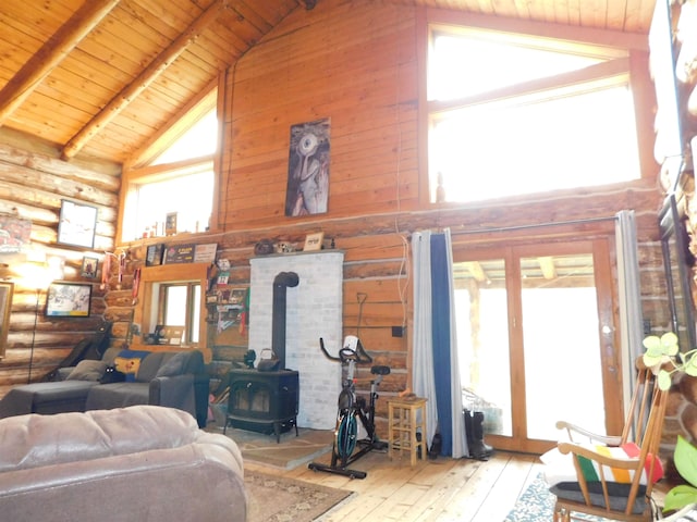 living room featuring light hardwood / wood-style floors, wood ceiling, a wood stove, high vaulted ceiling, and beamed ceiling