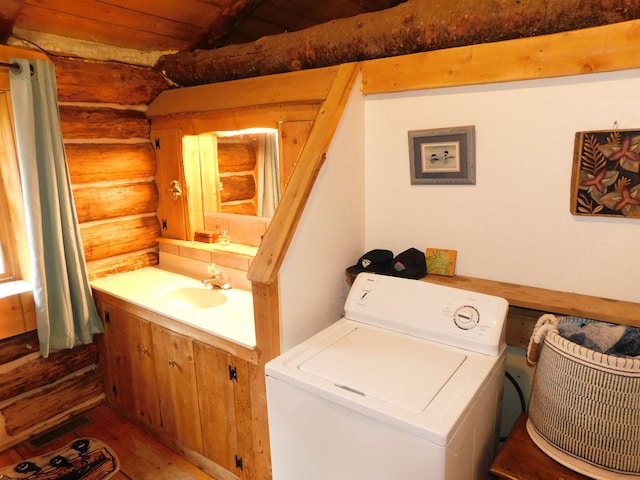 laundry room featuring washer / clothes dryer, rustic walls, sink, and wooden ceiling