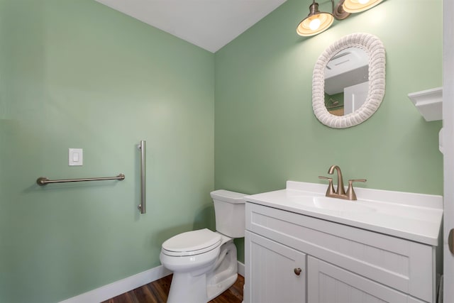 bathroom with wood-type flooring, vanity, and toilet