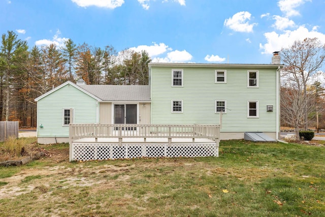 rear view of house featuring a lawn and a wooden deck