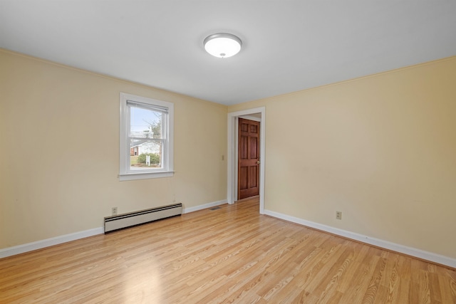 empty room with light hardwood / wood-style flooring and a baseboard heating unit