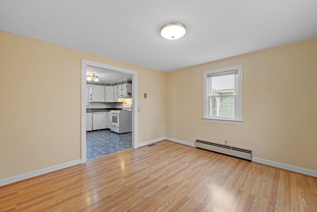 empty room with light hardwood / wood-style flooring and a baseboard radiator