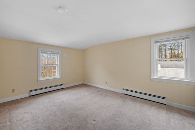 spare room with baseboard heating, light carpet, and a healthy amount of sunlight