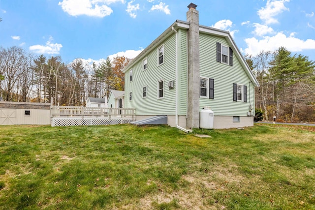 rear view of property with a deck and a lawn