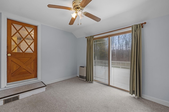 empty room featuring lofted ceiling, light colored carpet, and ceiling fan