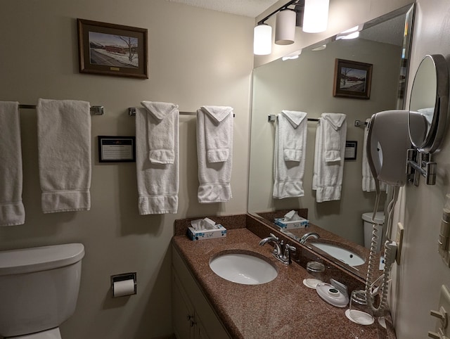 bathroom with vanity, a textured ceiling, and toilet