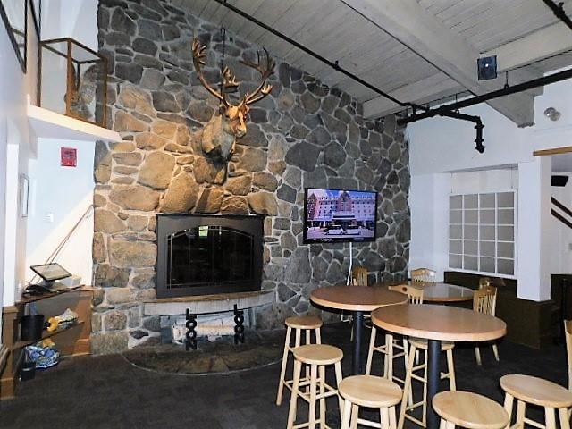 dining space with a high ceiling, beamed ceiling, and wooden ceiling