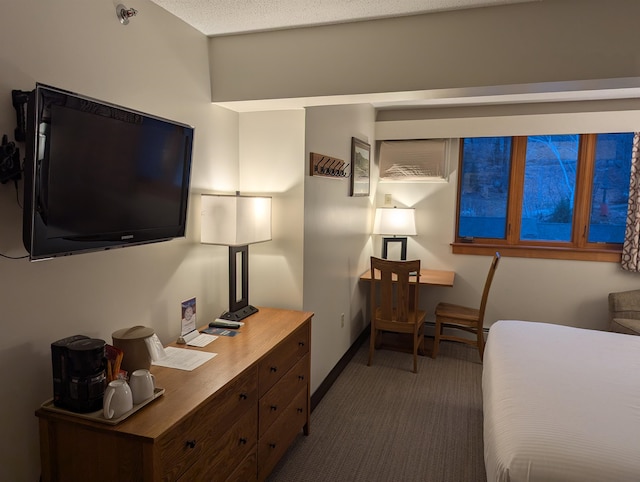 bedroom featuring a textured ceiling and dark carpet