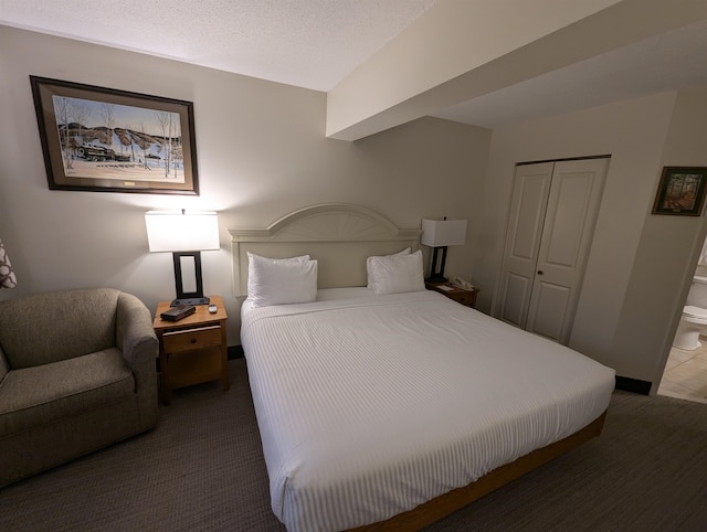 carpeted bedroom with a closet and a textured ceiling