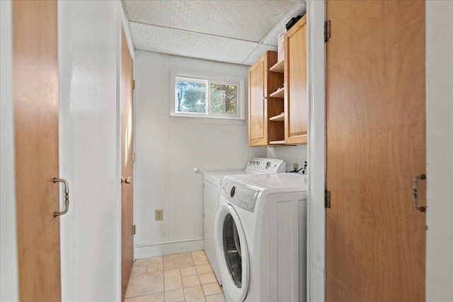 washroom featuring cabinets, independent washer and dryer, and light tile patterned floors