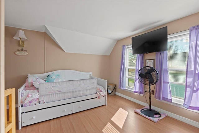 bedroom featuring light wood-type flooring and lofted ceiling