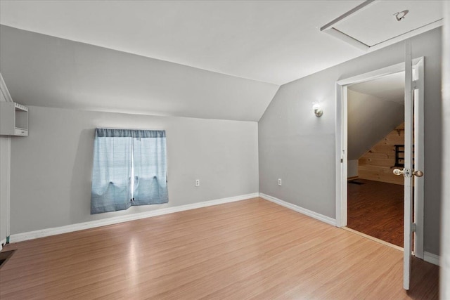 additional living space featuring light wood-type flooring and lofted ceiling