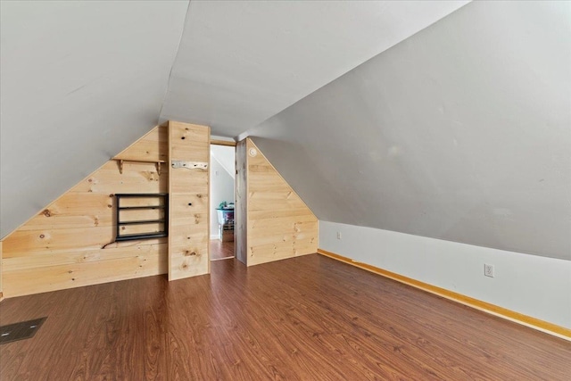 additional living space with dark hardwood / wood-style flooring and lofted ceiling