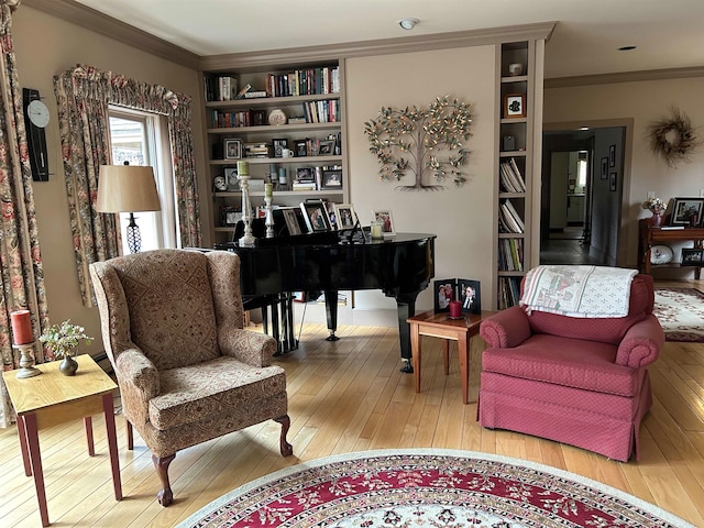 sitting room featuring ornamental molding, built in features, and wood-type flooring