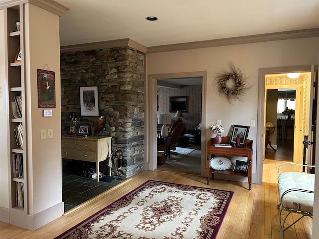 hallway with light hardwood / wood-style flooring, crown molding, and built in features