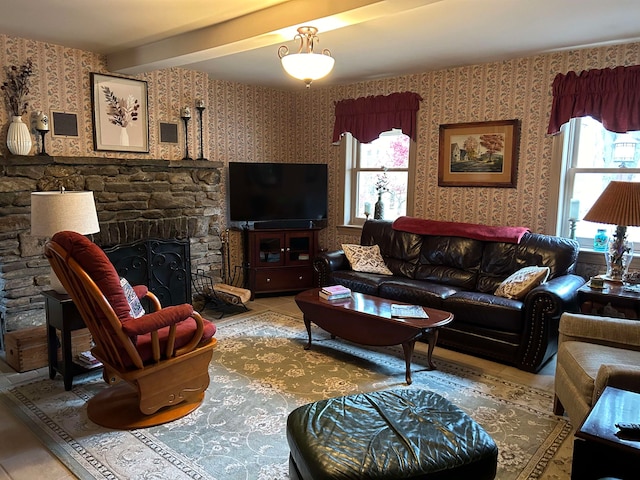 tiled living room featuring a stone fireplace, a healthy amount of sunlight, and beam ceiling