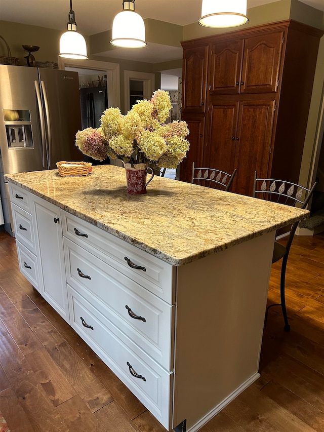 kitchen featuring white cabinets, a kitchen bar, and decorative light fixtures