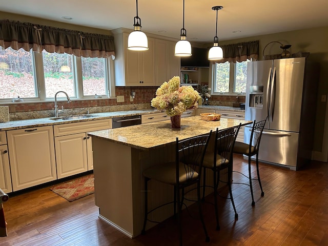 kitchen featuring dark wood-type flooring, a kitchen island, sink, and stainless steel appliances