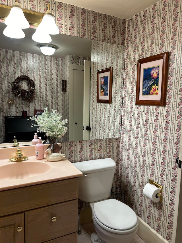 half bath featuring vanity, tile patterned flooring, and toilet