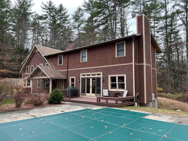 rear view of property featuring french doors and a pool side deck