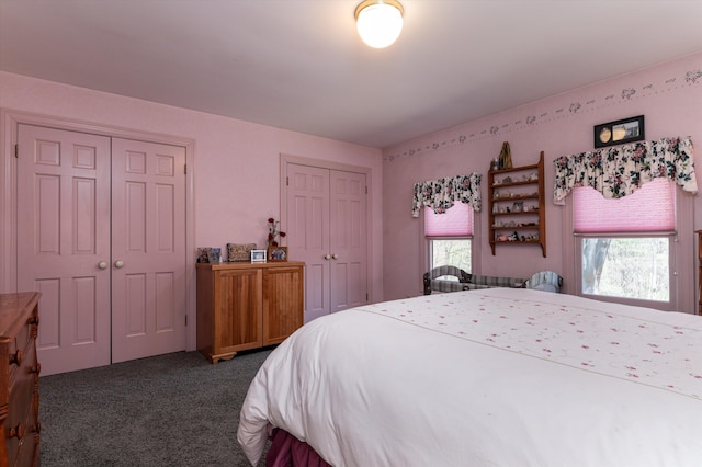 bedroom with dark carpet and multiple closets