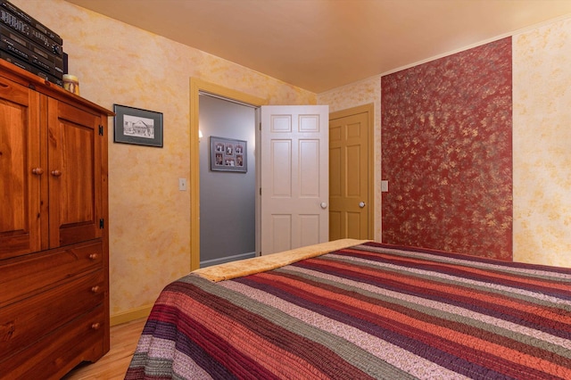 bedroom featuring light wood-type flooring and wallpapered walls