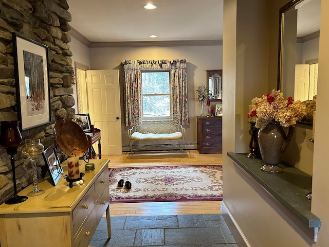 corridor with hardwood / wood-style flooring, crown molding, and a baseboard heating unit