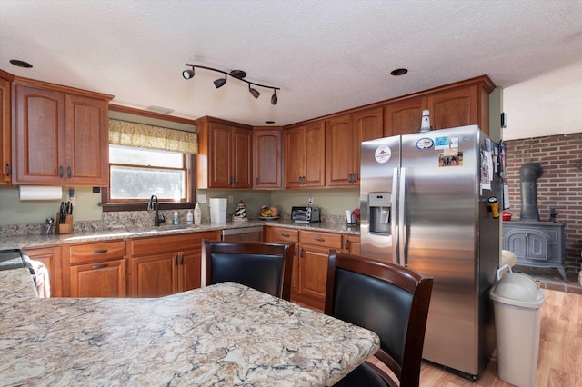 1319 Brandon Mountain Rd, Rochester, VT 05767 - kitchen featuring stainless steel refrigerator with ice dispenser, light wood-style flooring, a sink, light stone countertops, and a wood stove
