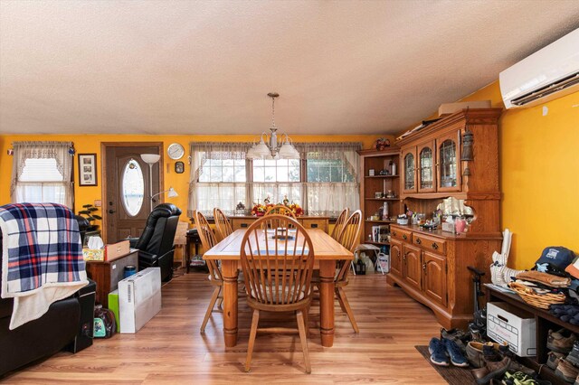 1319 Brandon Mountain Rd, Rochester, VT 05767 - dining room featuring a wall mounted AC, light wood-style floors, healthy amount of natural light, a chandelier, and a textured ceiling