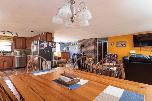 1319 Brandon Mountain Rd, Rochester, VT 05767 - dining area with a wood stove, light wood-style floors, and a chandelier