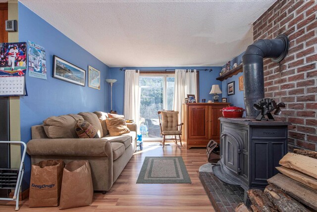 1319 Brandon Mountain Rd, Rochester, VT 05767 - living area featuring a wood stove, a textured ceiling, and light wood finished floors