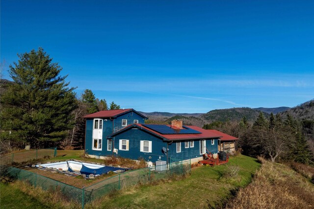 1319 Brandon Mountain Rd, Rochester, VT 05767 - back of property with solar panels, metal roof, a mountain view, and a chimney