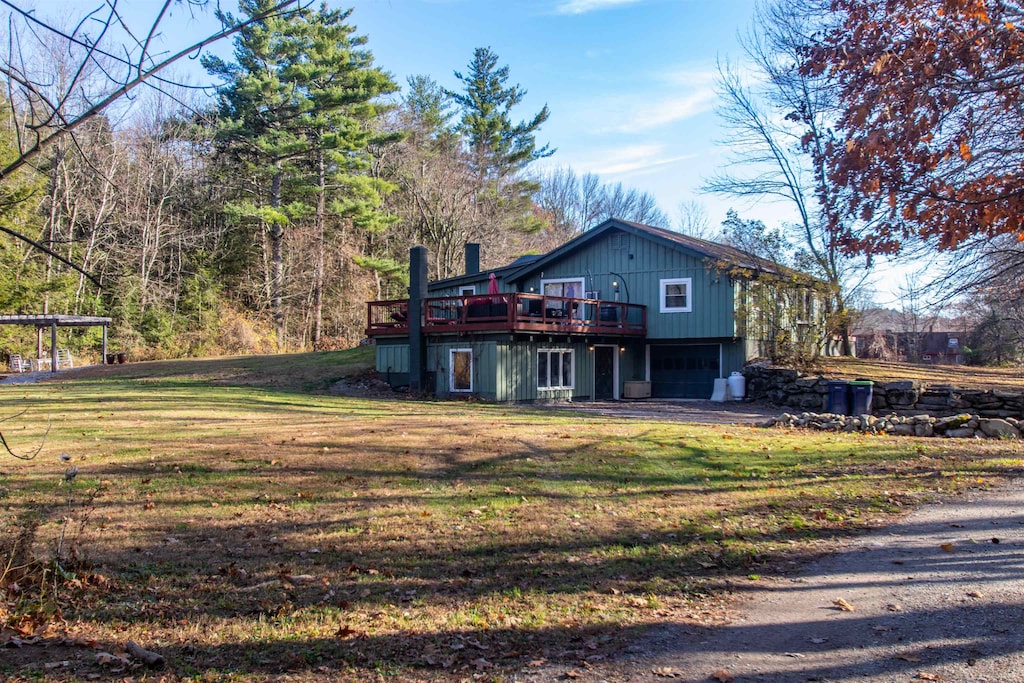 rear view of property featuring a wooden deck and a yard