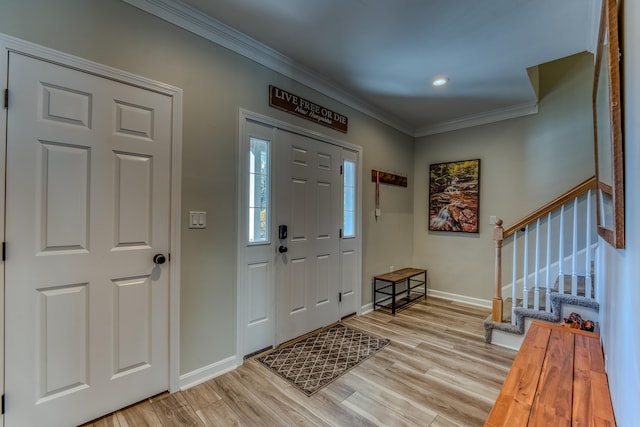 foyer entrance with light hardwood / wood-style floors and crown molding