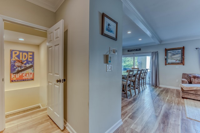 hallway with light wood-type flooring and crown molding