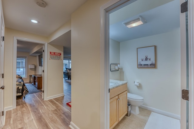 bathroom featuring wood-type flooring, vanity, and toilet