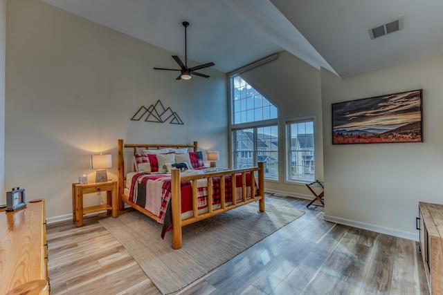 bedroom featuring hardwood / wood-style floors, ceiling fan, and high vaulted ceiling